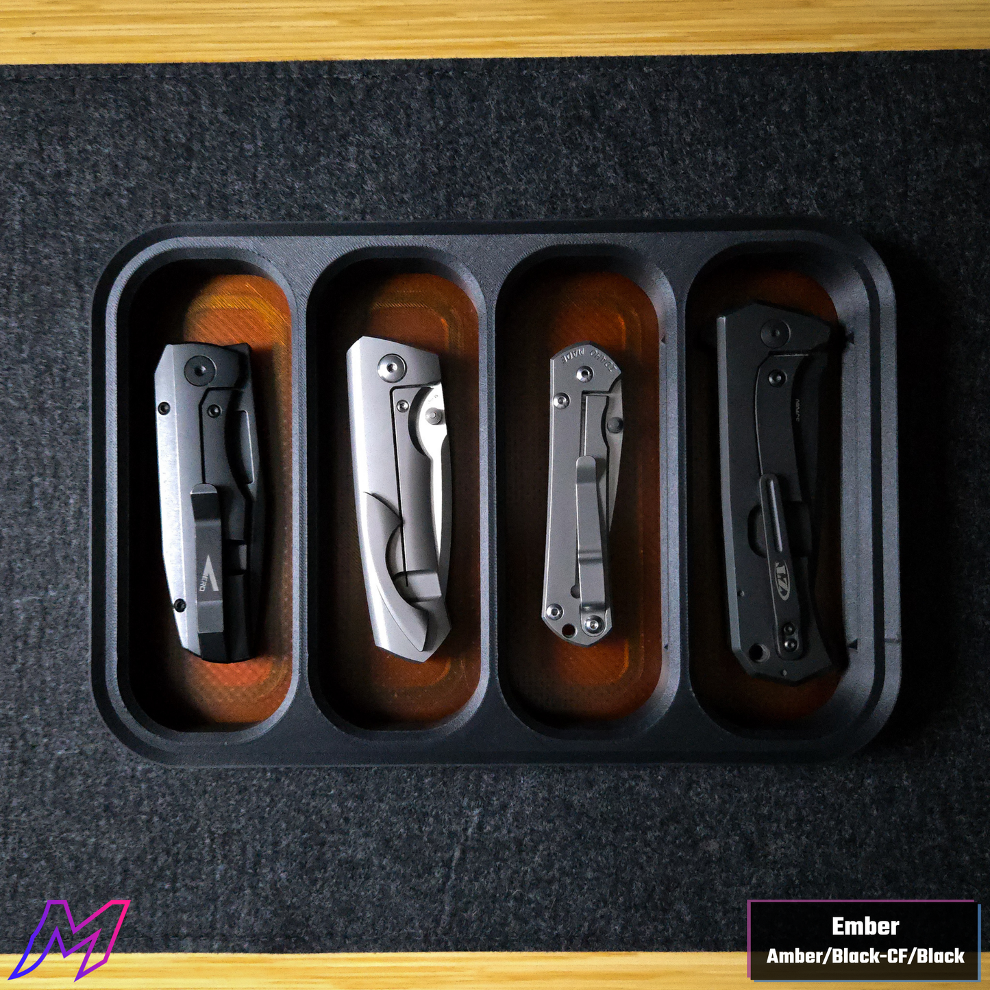 MATERIUM Vanguard Catch Ember colorway top-down with 4 folding knives loaded on amber resin base
