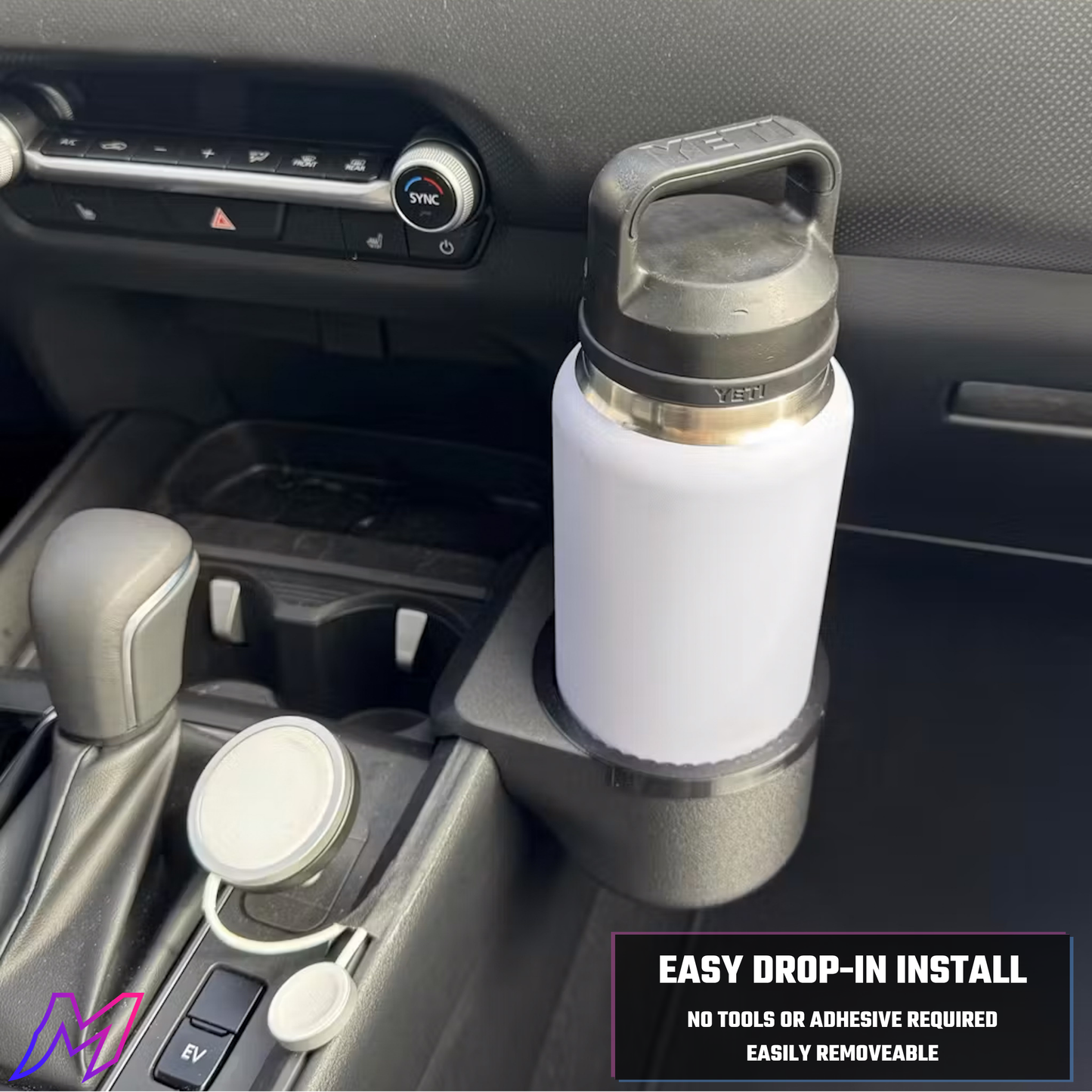 White insulated cup holder with silver lid installed in a car cup holder.