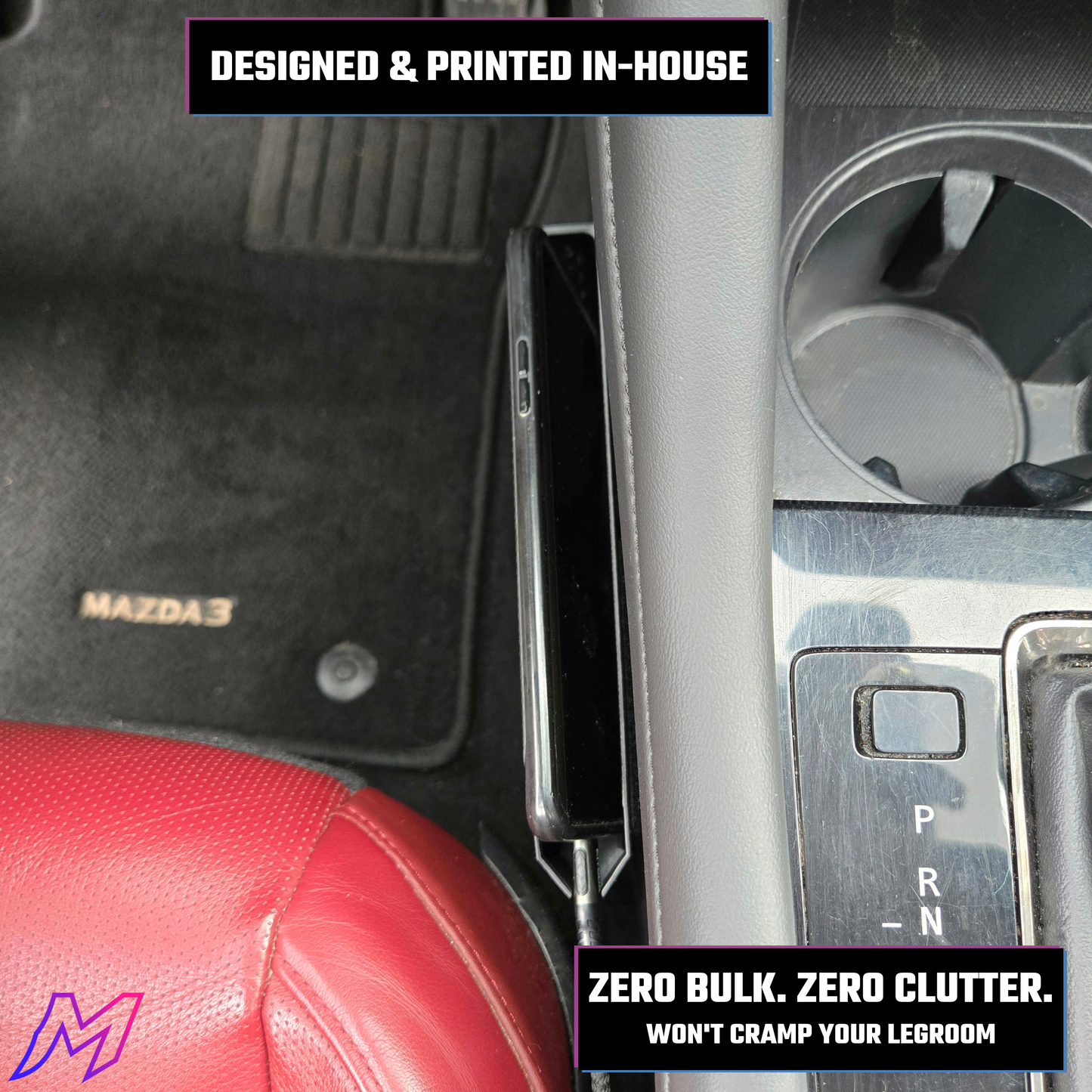Car interior with a Mazda3 logo on a floor mat, showing a close-up of the gear shift and red seat.